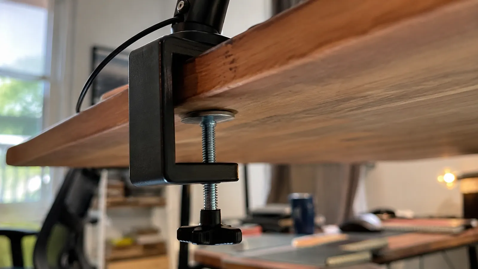Desk clamp base of the Airlonv lamp attached to the edge of a wooden desk, viewed from underneath